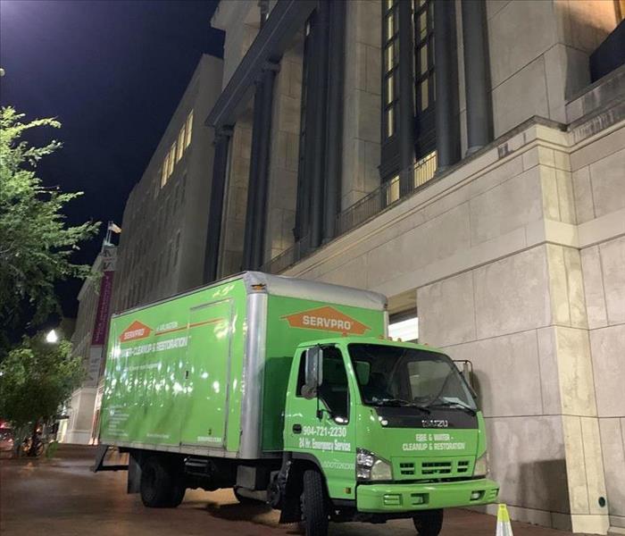 A SERVPRO truck parked outside a large building. 
