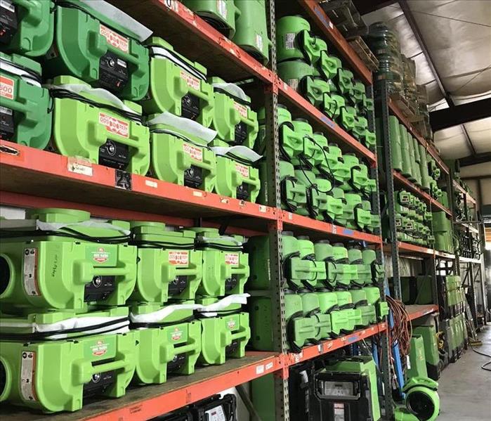 Several sets of shelves with large amounts of SERVPRO equipment on the shelves.  