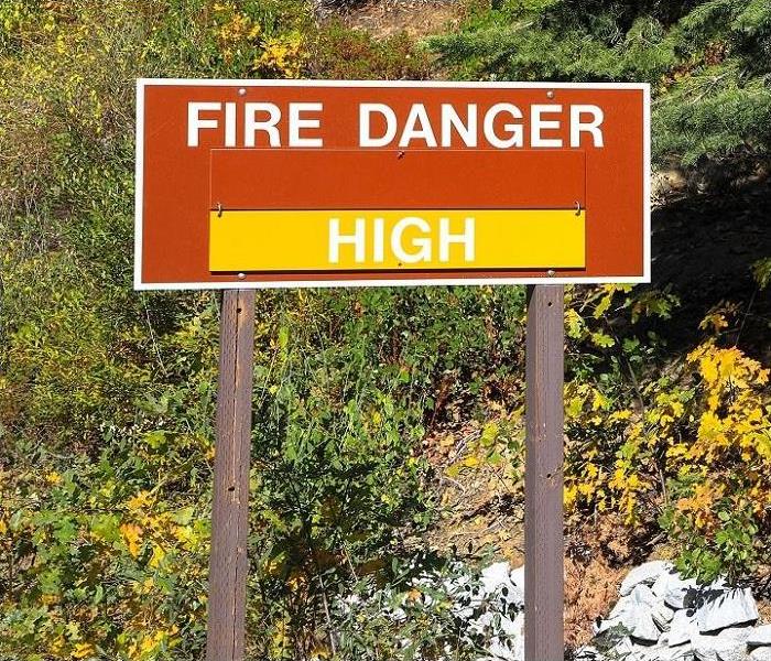 Fire danger sign; drying brush in background